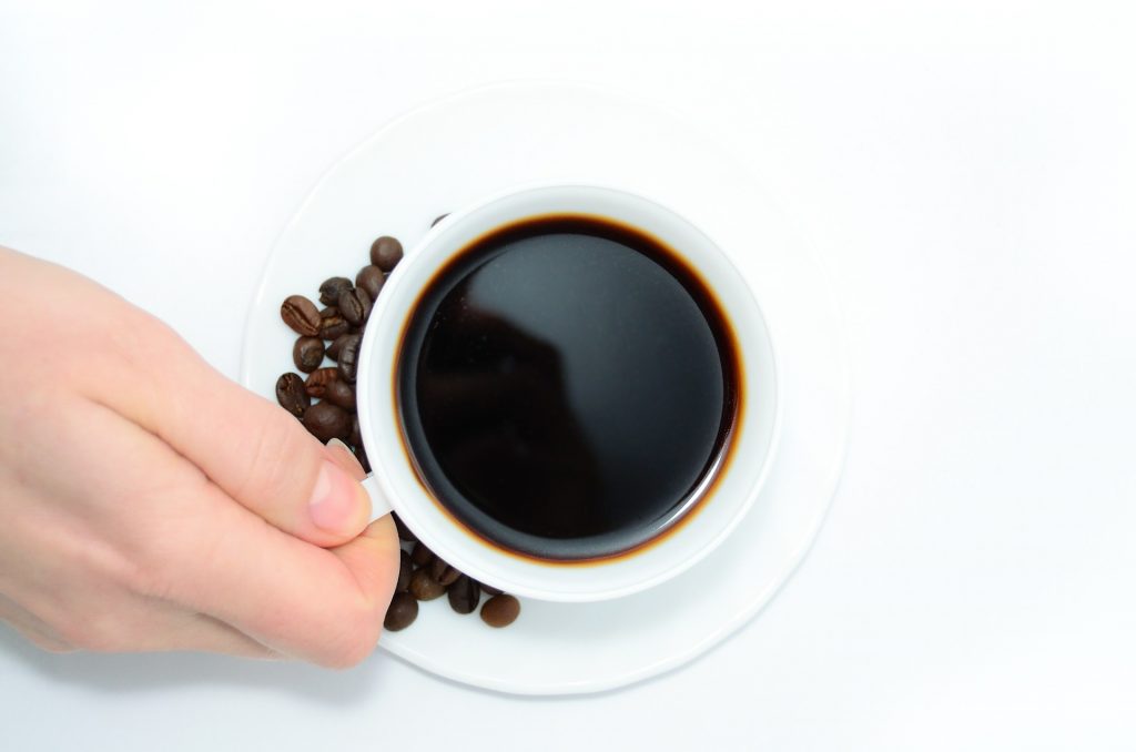 cup of coffee with coffee beans on the side